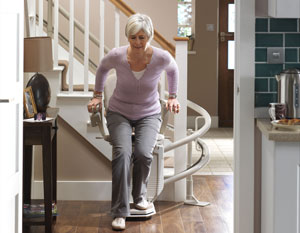 Woman getting on curved stairlift